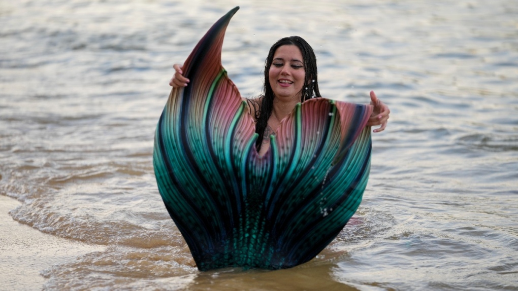 Lauren Metzler, founder of Sydney Mermaids, prepares for a swim at Manly Cove Beach in Sydney, Australia, on May 26, 2022. (Mark Baker / AP) 