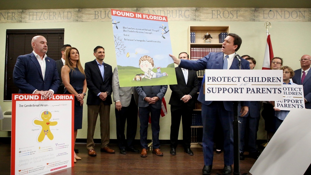 Florida Gov. Ron DeSantis shows an image from the children's book Call Me Max by transgender author Kyle Lukoff moments before signing the Parental Rights in Education bill during a news conference on Monday, March 28, 2022, at Classical Preparatory school in Shady Hills. (Douglas R. Clifford/Tampa Bay Times via AP) 