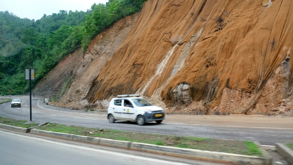 Nets cover a slope by a road to prevent soil from slipping on the highway near Medziphema, in the northeastern India state of Nagaland, Tuesday, May 17, 2022. Officials in India say more than 10 people have died in floods and mudslides triggered by heavy rains in the country's northeast region. (AP Photo/Yirmiyan Arthur)