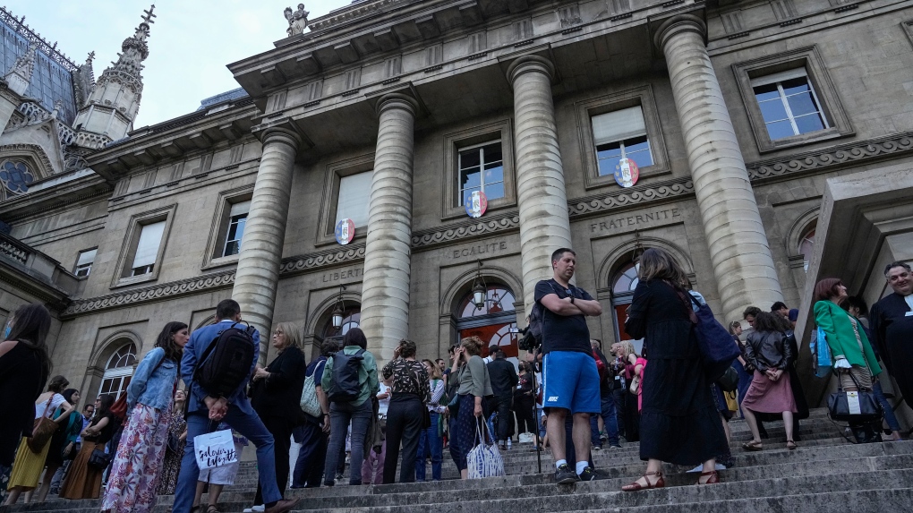 Lawyers and trial goers gather outside the court house after the verdict in Paris Wednesday, June 29, 2022. (AP Photo/Michel Euler)