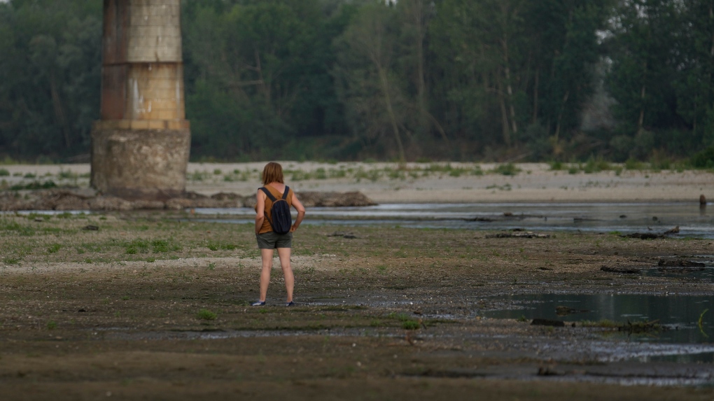 A woman stands on the Po riverbed next to Ponte della Becca (Becca bridge) in Linarolo, near Pavia, Italy, on June 27. (Luca Bruno/AP)