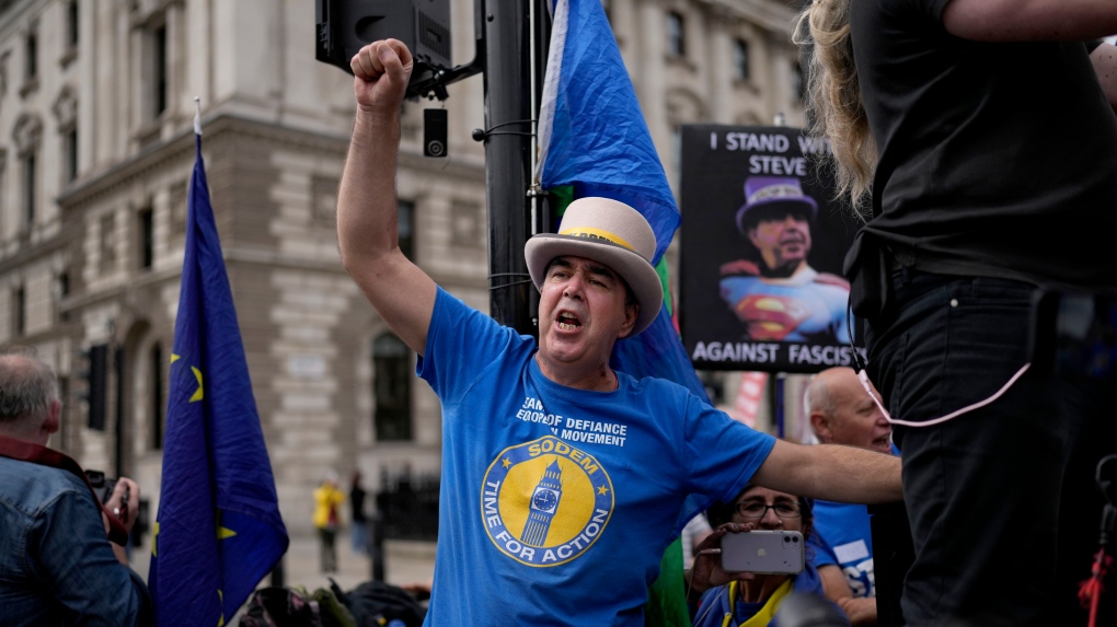 Anti-Brexit protesters including Steve Bray sing to music as they stand on a traffic island, across the street from the Houses of Parliament, in London, Wednesday, June 29, 2022. (AP Photo/Matt Dunham)
