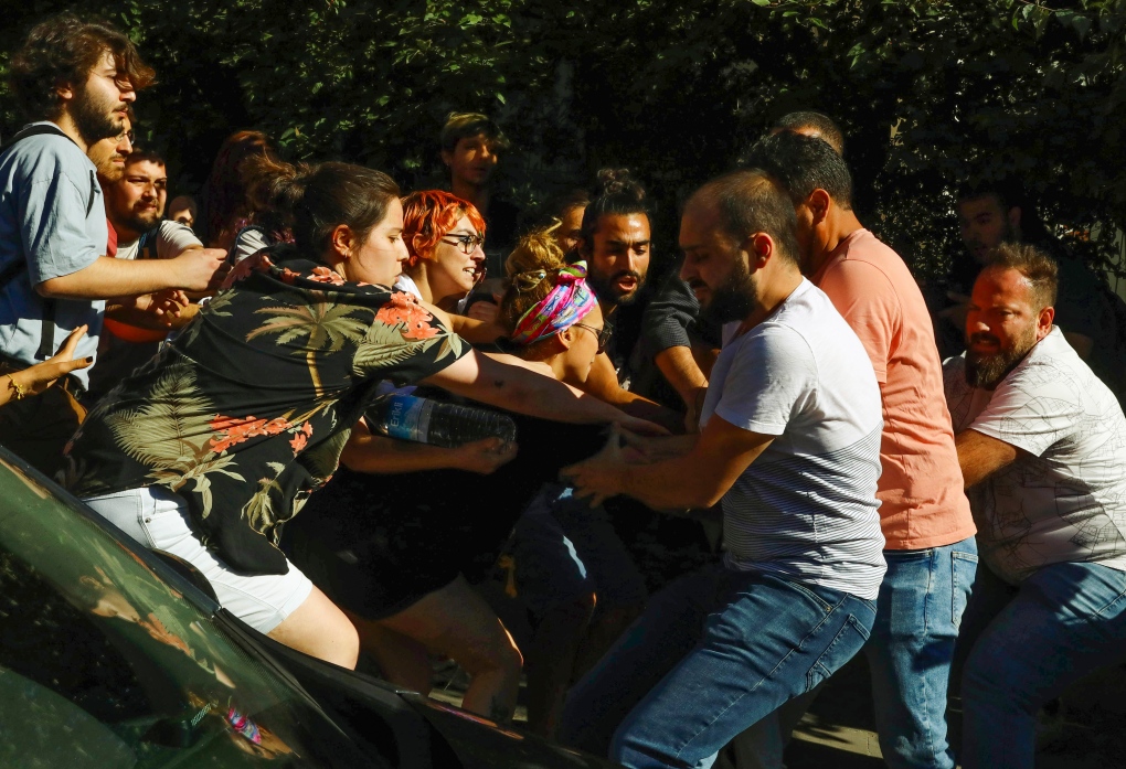 Turkish plain clothes policemen, right, scuffle with protesters during the LGBTQ Pride March in Ankara, Turkey, Tuesday, July 5, 2022. Police in Turkey's capital have broken up a LGBTQ Pride march and detained dozens of people. Turkish authorities have banned LGBTQ events. (AP Photo/Ali Unal)