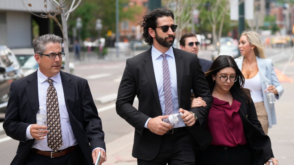 A defence investigator, left, for Pittsburgh dentist Lawrence "Larry" Rudolph heads into federal court with the dentist's children, front centre and back right, for the afternoon session of the trial, July 13, 2022, in Denver. (AP Photo/David Zalubowski)