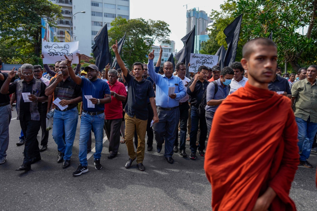 Trade union and civil society activists led by leftists' People Liberation Front shout slogans denouncing president Ranil Wickremesinghe as they march in streets in Colombo, Sri Lanka on Aug. 9, 2022. Hundreds of Sri Lankans Tuesday rallied against a government crackdown and the use of emergency laws against those who protested peacefully against the country's worst economic crisis in recent memory. (AP Photo/Eranga Jayawardena)