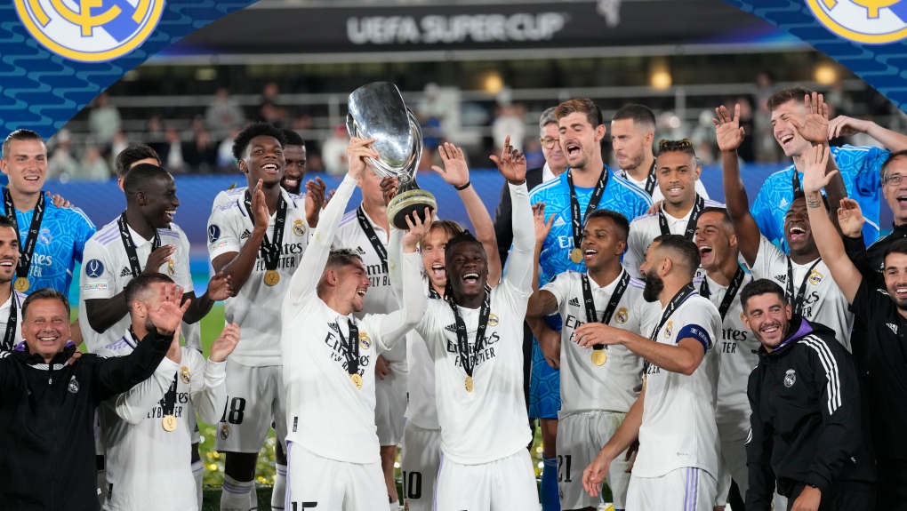 Real Madrid's Federico Valverde, left, and Real Madrid's Eduardo Camavinga lift the trophy after winning the UEFA Super Cup final soccer match between Real Madrid and Eintracht Frankfurt at Helsinki's Olympic Stadium, Finland, Wednesday, Aug. 10, 2022. Real Madrid won 2-0. (AP Photo/Antonio Calanni)