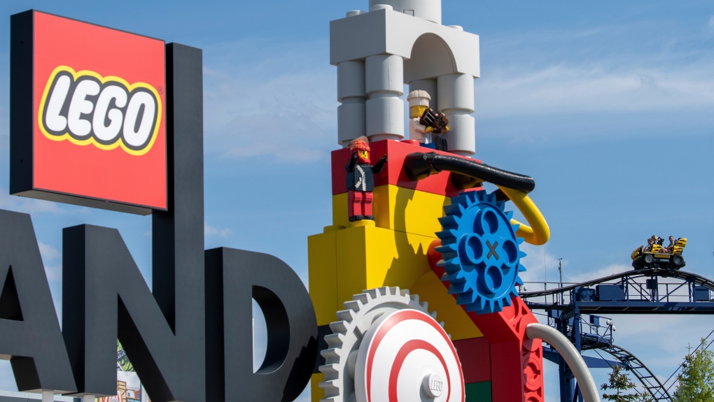 A roller coaster can be seen next to the logo at the entrance to the 'Legoland' amusement park in Guenzburg, southern Germany, Thursday, Aug. 11, 2022. (Stefan Puchner/dpa via AP)