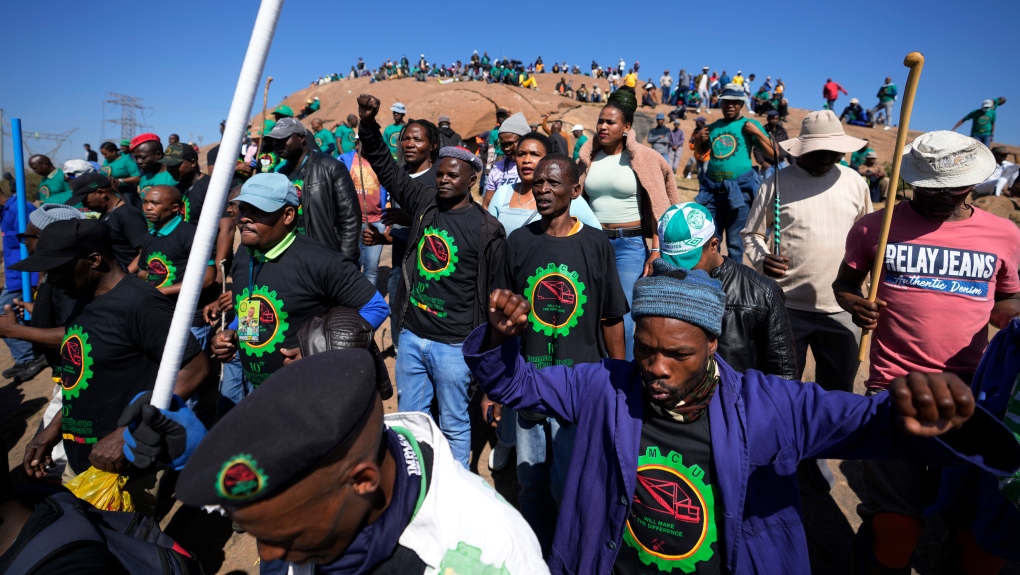 Mine workers sing as they wait for the start of commemoration ceremonies near Marikana in Rustenburg, South Africa, Tuesday, Aug. 16, 2022. (AP Photo/Themba Hadebe)