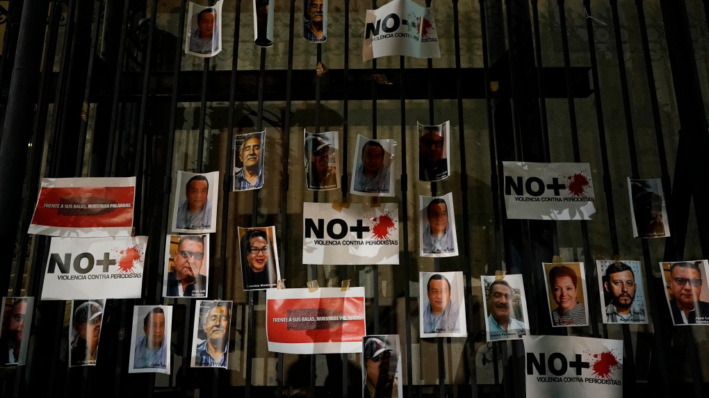 Photos of slain journalists are posted on the gate of Mexico's Attorney General's office during a vigil to protest the murder of journalist Heber Lopez, in Mexico City, Monday, Feb. 14, 2022.  (AP Photo/Eduardo Verdugo)