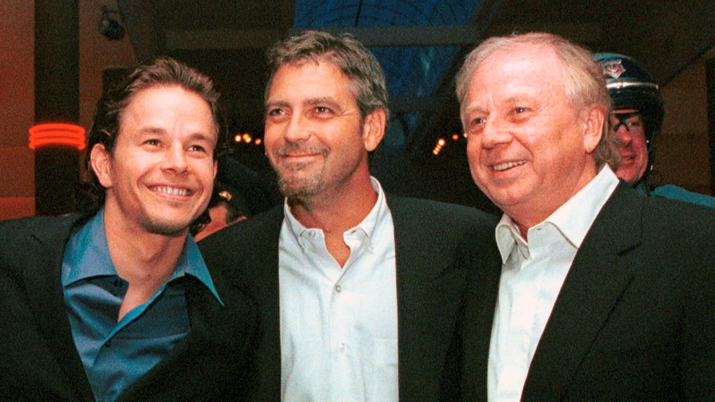 Actors Mark Wahlberg, left, and George Clooney, centre, stars of the film "The Perfect Storm,'' pose with director/producer Wolfgang Petersen at the premiere in Danvers, Mass., on June 28, 2000. (AP Photo/Lisa Poole, File)
