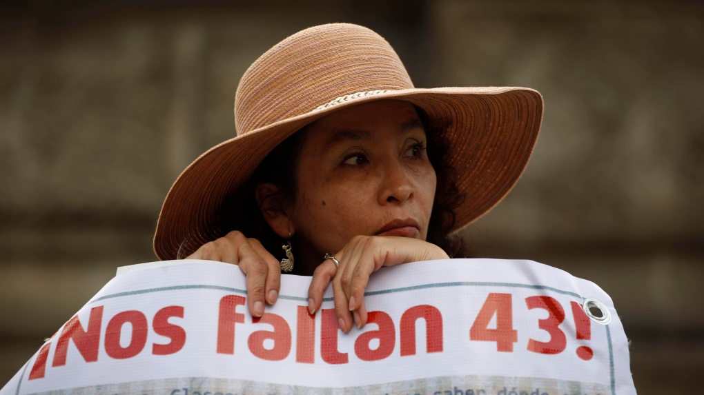 A woman carries a banner that reads in Spanish "We are missing 43," referring to the 43 missing students from a rural teachers college during a march in Mexico City, Thursday, Nov. 26, 2015. The Truth Commission created to find out what happened to the missing students presented on Thursday, Aug. 18, 2022, a report that hints at the possible responsibility of the Mexican army in the disappearance. (AP Photo/Eduardo Verdugo, File)