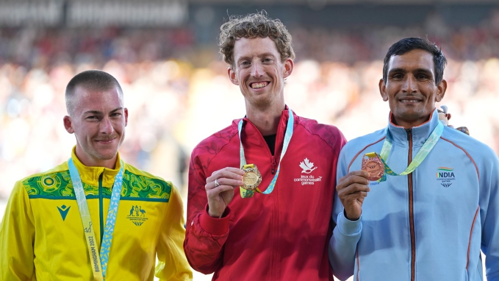 Silver medalist Declan Tingay of Australia, gold medalist Evan Dunfee of Canada and bronze medalist Sandeep Kumar of India, from left to right, pose with their medals on the podium of the Men's 10,000-metre race walk during the athletics competition in the Alexander Stadium at the Commonwealth Games in Birmingham, England, Aug. 7, 2022. (AP Photo/Alastair Grant)