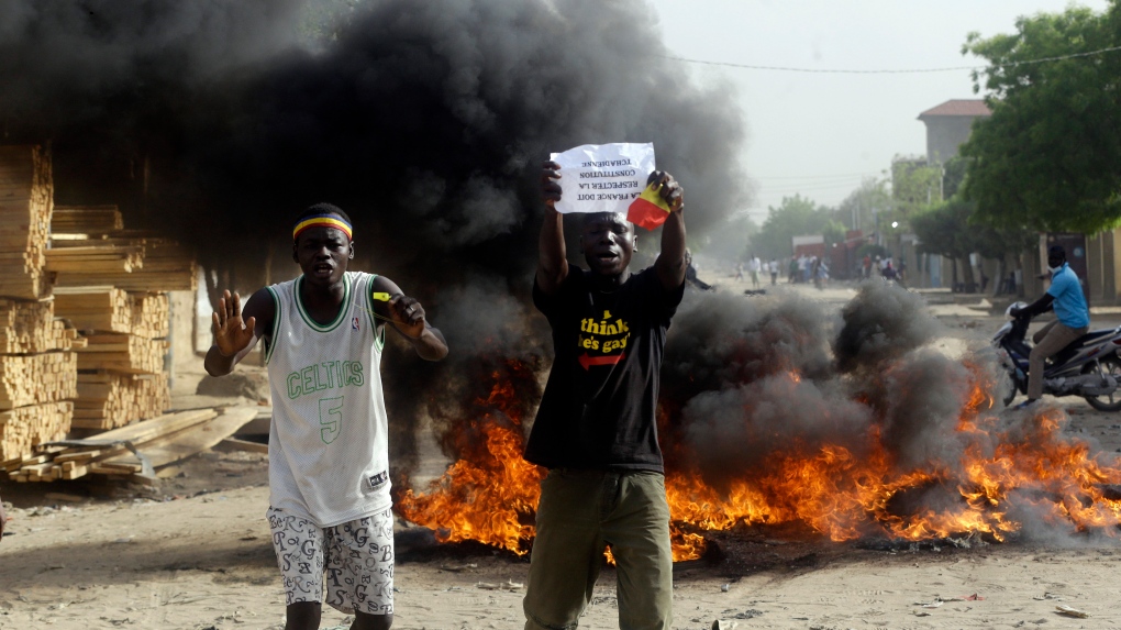 Two men protest on a street in N'Djamena, Chad, Tuesday, April 27, 2021. (AP Photo/Sunday Alamba)