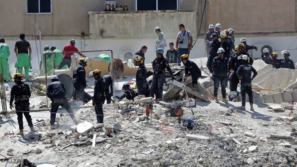 Jordanian Civil Defense rescue teams conduct a search operation for residents of a four-story residential building that collapsed on Tuesday, killing several people and wounding others, in the Jordanian capital of Amman, Wednesday Sept. 14, 2022. (AP Photo/Raad Adayleh)