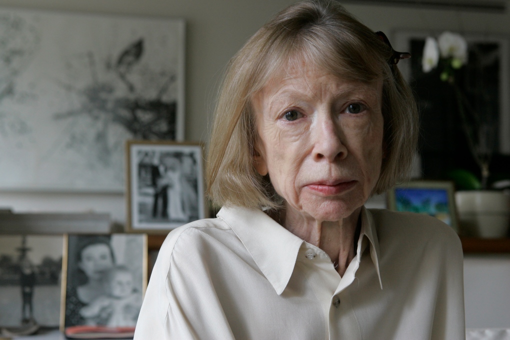 Author Joan Didion sits in front of a photo of herself holding her daughter, Quintana Roo, and another picture of her daughter's wedding, in her New York apartment Sept. 26, 2005. She died in December 2021 at the age of 87. (AP Photo/Kathy Willens, File)