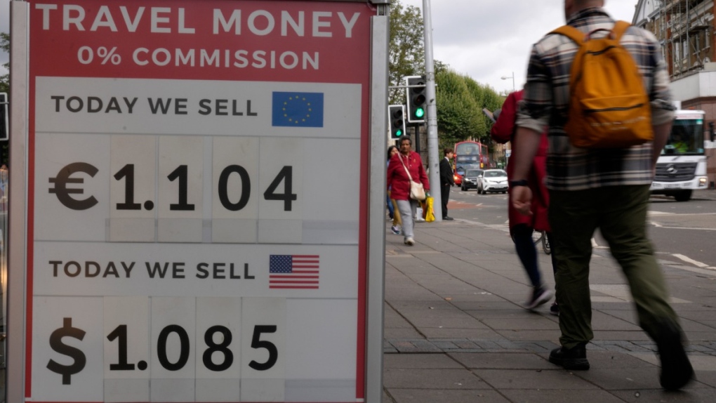 Pedestrians pass a currency exchange sign outside a shop in London, on Sept. 23, 2022.  (Kirsty Wigglesworth / AP) 