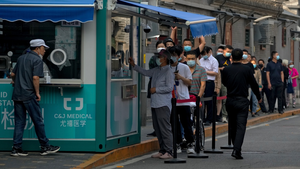 Residents line up to get their routine COVID-19 throat swabs at a coronavirus testing site along a hutong alley in Beijing, Wednesday, Sept. 28, 2022. (AP Photo/Andy Wong)