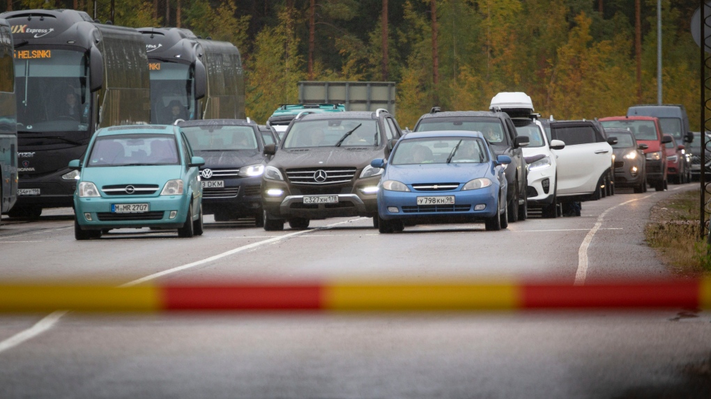 Russian cars and buses line up at the Vaalimaa border check point between Finland and Russia in Virolahti, Finland, Friday, Sept. 30, 2022. The Finnish-Russia border was closed Friday after the Nordic country announced it would ban Russians with tourist visas from entering, curtailing one of the last easily accessible routes to Europe for Russians trying to flee a military mobilization. Long queues were reported until midnight and among the last to enter Finland were two cyclists who arrived a little before 11 p.m., Finnish broadcaster YLE reported. (Sasu Makinen./Lehtikuva via AP)
