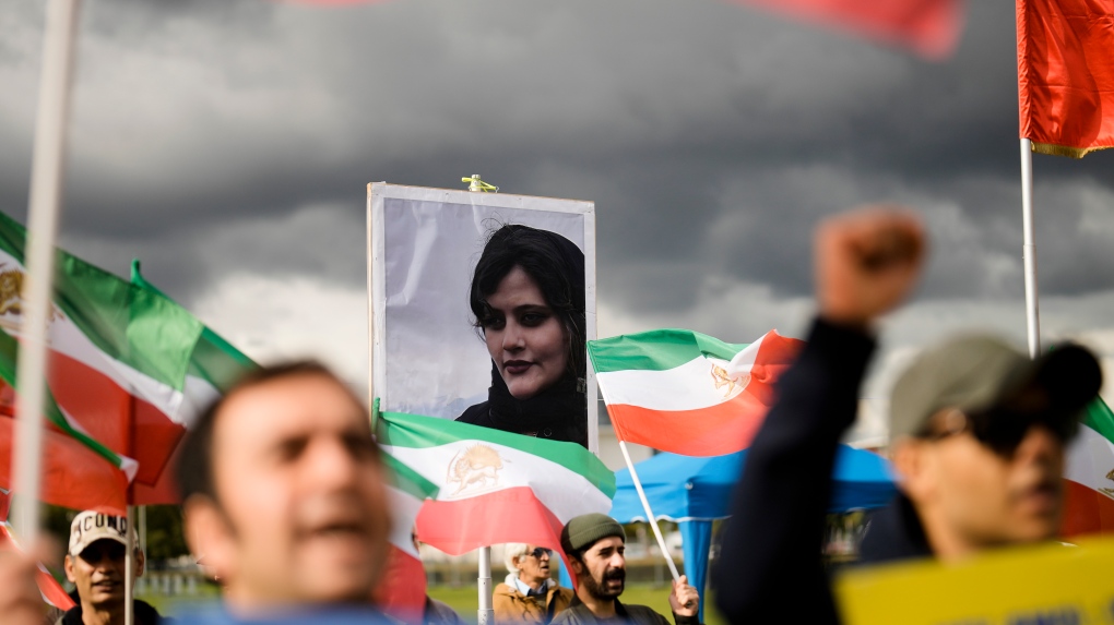 A photo of Iranian Mahsa Amini is shown during a protest of the 'National Council of Resistance of Iran' in Berlin, Germany, Wednesday, Sept. 28, 2022. Amini, a 22-year-old woman who died in Iran while in police custody, was arrested by Iran's morality police for allegedly violating its strictly-enforced dress code. (AP Photo/Markus Schreiber)