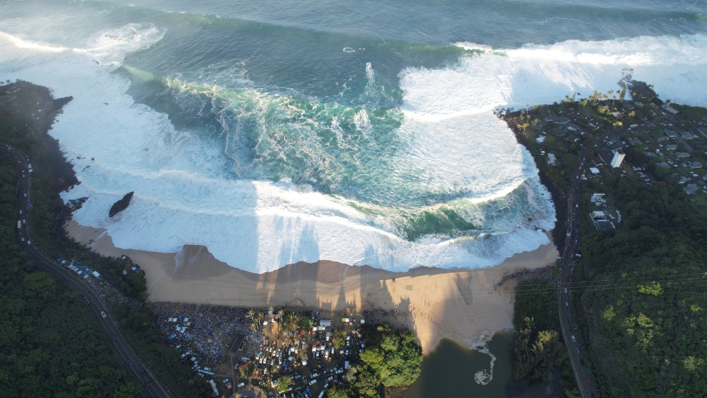 This aerial image provided by Clark Little shows the crowds gathered for the Eddie Aikau Big Wave Invitational surf competition at Waimea Bay, Hawaii, on Oahu’s North Shore, Sunday, Jan. 22, 2023. (Clark Little via AP)