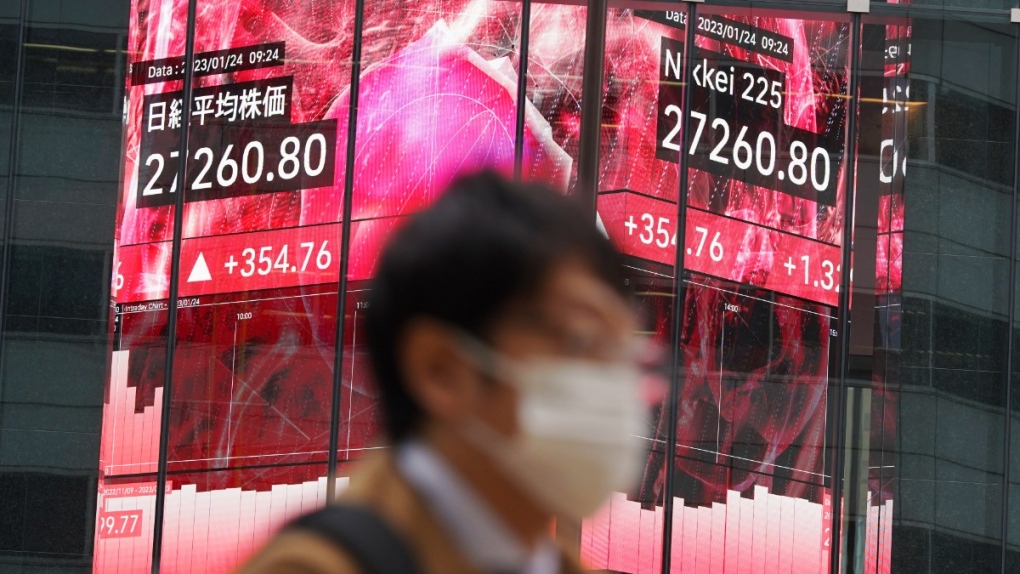 A person walks in front of an electronic stock board showing Japan's Nikkei 225 index at a securities firm, Jan. 24, 2023, in Tokyo. (AP Photo/Eugene Hoshiko)