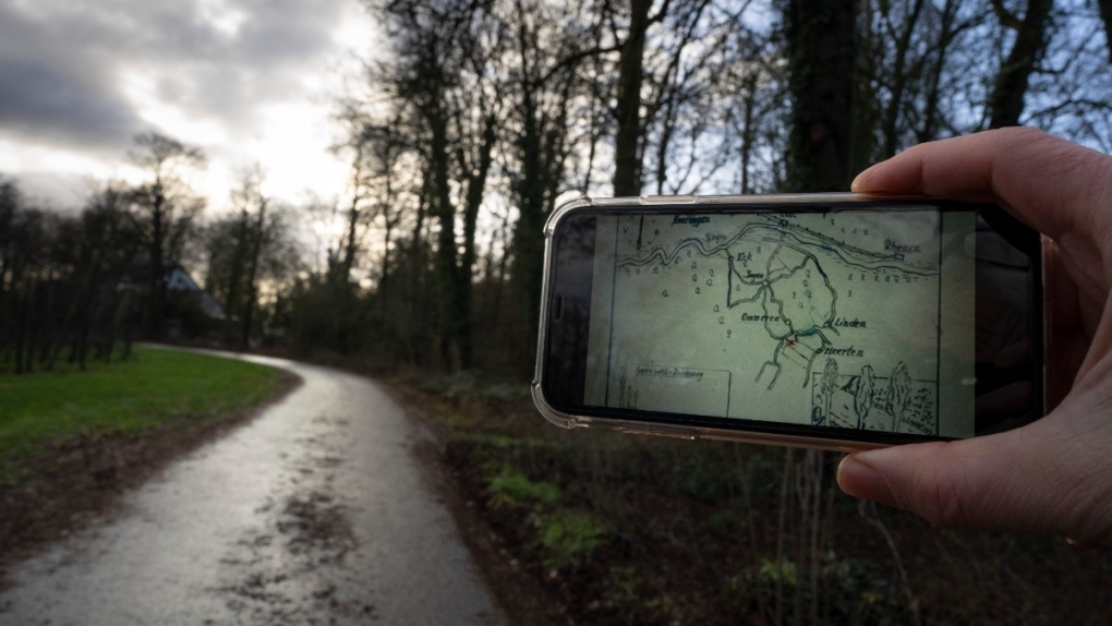 A mobile phone shows the map of the buried Nazi loot on the location of the former dirt road in Ommeren, near Arnhem, Netherlands, on Jan. 19, 2023.  (Peter Dejong / AP) 