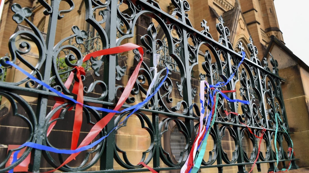 Ribbons are tied onto a fence as a protest at St Mary's Cathedral, in Sydney, Tuesday, Jan. 31, 2023. Police plan to ask a judge to ban gay rights protesters from demonstrating outside St. Mary's Cathedral during Australian Cardinal George Pell's Sydney funeral Wednesday. (Bianca De Marchi/AAP Image via AP)
