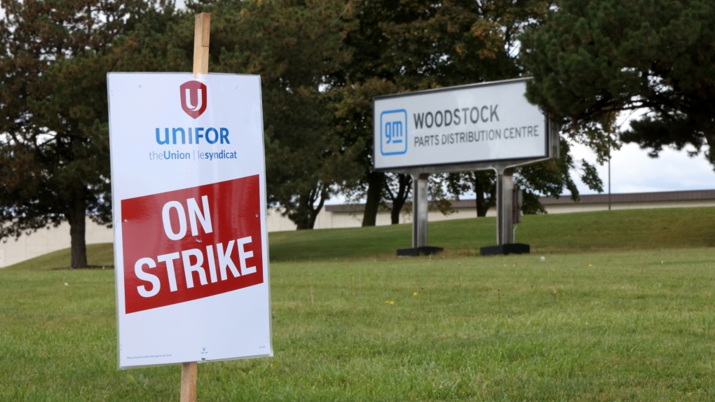 A Unifor on strike placard is seen on the lawn in front of the sign at the Woodstock Parts Distribution Centre as GM staff strike, in Woodstock, Ont., Oct. 10, 2023. THE CANADIAN PRESS/Nicole Osborne