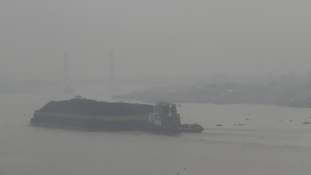 A boat sails on Musi River as thick haze from forest fires shroud the city of Palembang, South Sumatra, Indonesia, Monday, Oct. 2, 2023. (AP Photo/Muhammad Hatta)