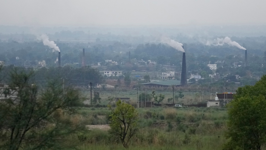 Smoke rises from chimneys of a bricks factory on the outskirts of Jammu, India, Tuesday, May 2, 2023. (AP Photo/Channi Anand)