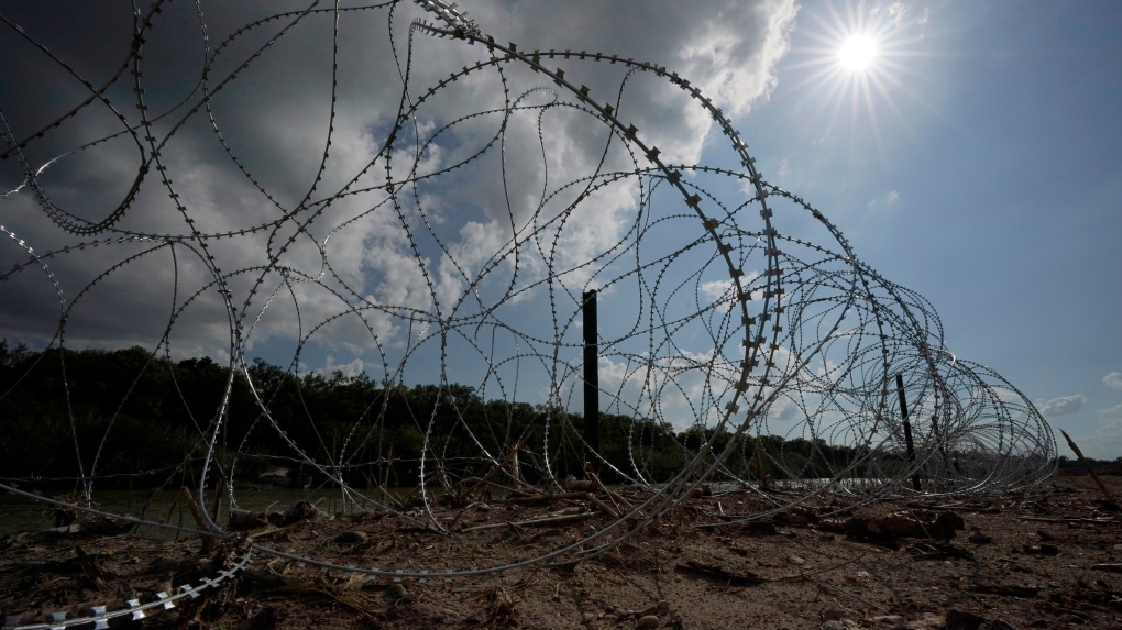 
FILE - Concertina wire lines the banks of the Rio Grande on the Pecan farm of Hugo and Magali Urbina, near Eagle Pass, Texas, Monday, July 7, 2023. A dispute over razor wire that Texas installed on the U.S.-Mexico border to deter migrants continued Thursday, Nov. 30, 2023, after a judge allowed Border Patrol agents to continue cutting the barrier but also laid into the Biden administration over immigration enforcement. (AP Photo/Eric Gay, File)