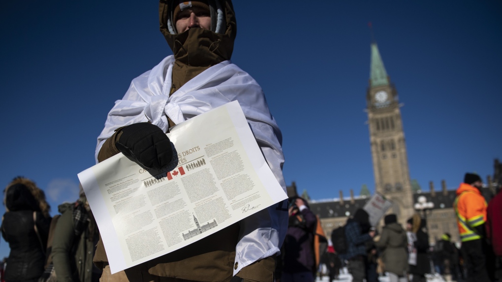 A person holds a copy of the Charter of Rights and Freedoms during a rally against COVID-19 restrictions on Parliament Hill, which began as a cross-country convoy protesting a federal vaccine mandate for truckers, in Ottawa, on Saturday, Jan. 29, 2022. (THE CANADIAN PRESS/Justin Tang)