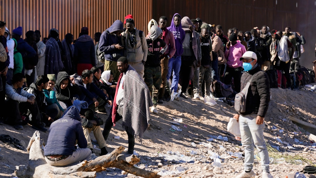 Hundreds of migrants gather along the border after breaking through gaps in the border wall Tuesday, Dec. 5, 2023, in Lukeville, Ariz. The U.S. Border Patrol says it is overwhelmed by a shift in human smuggling routes, with hundreds of migrants from faraway countries like Senegal, Bangladesh and China being dropped in the remote desert area in Arizona. (AP Photo/Ross D. Franklin)