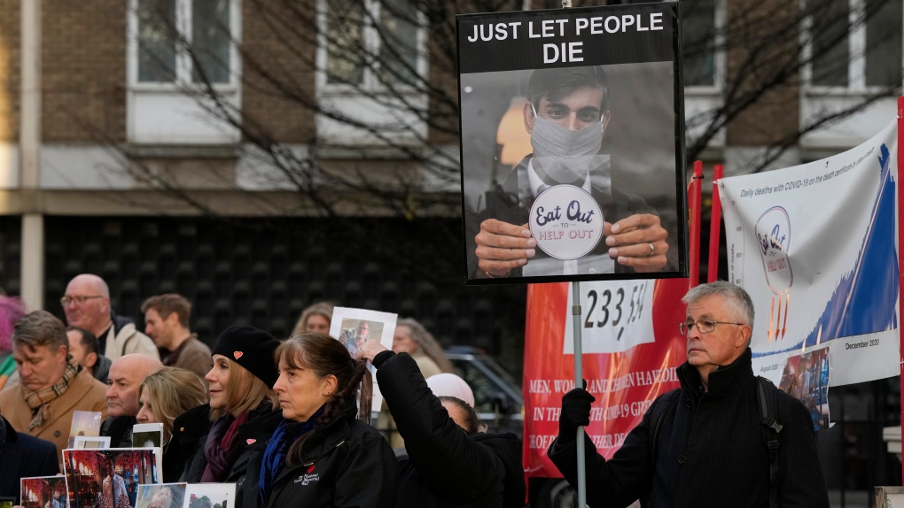 COVID campaigners and families of those who died during the pandemic hold placards outside COVID Inquiry at Dorland House, where British Prime Minister Rishi Sunak is giving evidence, in London, Monday, Dec. 11, 2023. (AP Photo/Frank Augstein)