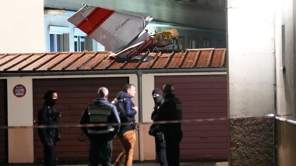 Police officers stand by the tail of a small plane that made an emergency landing in a residence, Monday, Dec. 4, 2023 in Villejuif, outside Paris.The communications director for the safety agency known as BEA for short, said the cause of the unplanned landing was a "technical problem" and that four people were on board the plane, including the pilot. (AP Photo/Michel Euler)