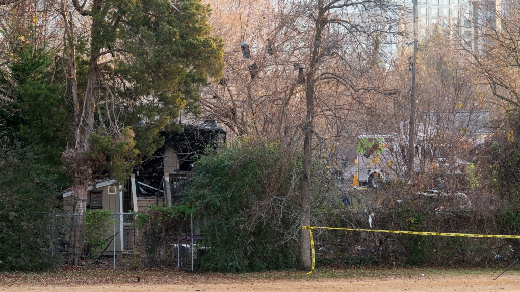Debris hangs in the trees near the remains of a house explosion on Tuesday, Dec. 5, 2023, in Arlington, Va. (AP Photo/Kevin Wolf)