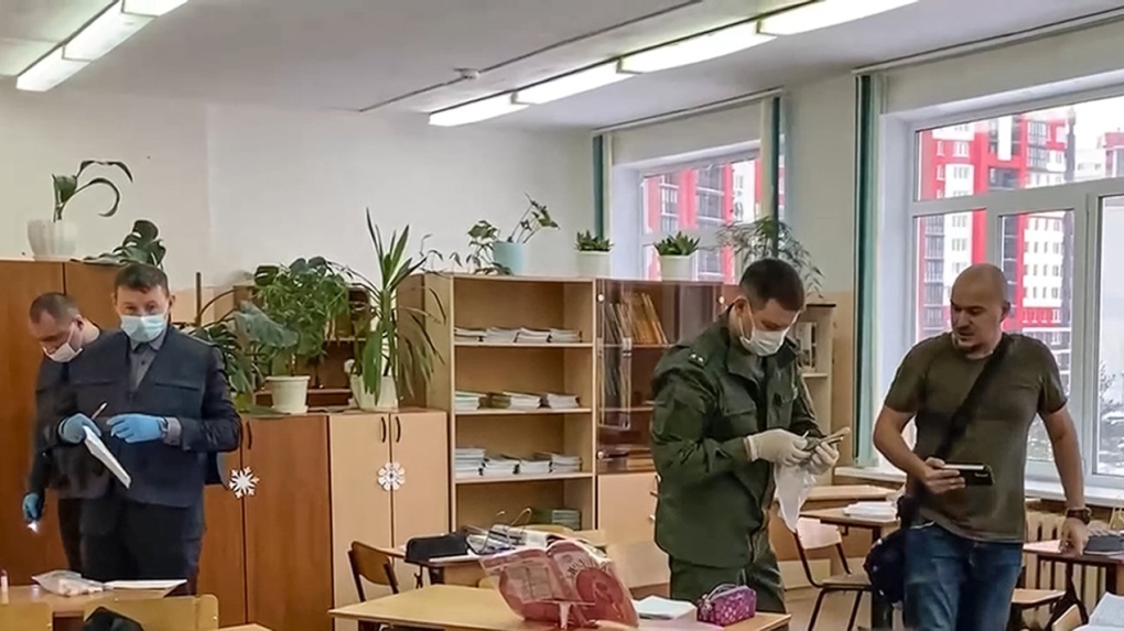 In this photo taken from video released by Russian Investigative Committee on Thursday, Dec. 7, 2023, investigators work at the scene of shooting in a class-room of a school in Bryansk, Russia. (Russian Investigative Committee via AP)