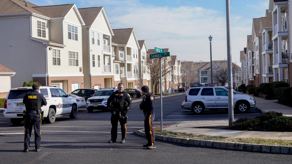 Sayreville police officers stand watch outside a townhome community, Thursday, Feb. 2, 2023, in Parlin, a section of Sayreville, , N.J., where Sayreville councilwoman Eunice Dwumfour was found shot to death in an SUV parked outside her home on Wednesday. According to the Middlesex County prosecutor's office, she had been shot multiple times and was pronounced dead at the scene. (AP Photo/Seth Wenig)