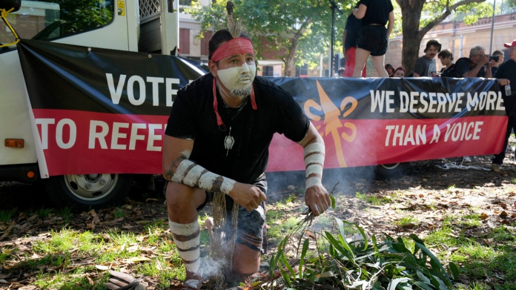 Aboriginal man Josh Sly of the Muggera Dancers prepares a fire for a smoking ceremony at the start of an Invasion Day rally in Sydney, on Jan. 26, 2023. (Rick Rycroft / AP) 