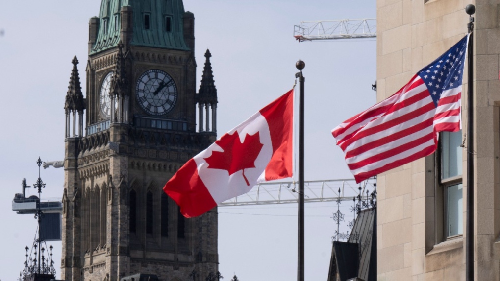 Canadian and United States flags are seen flying near Parliament Hill, March 22, 2023, in Ottawa. THE CANADIAN PRESS/Adrian Wyld