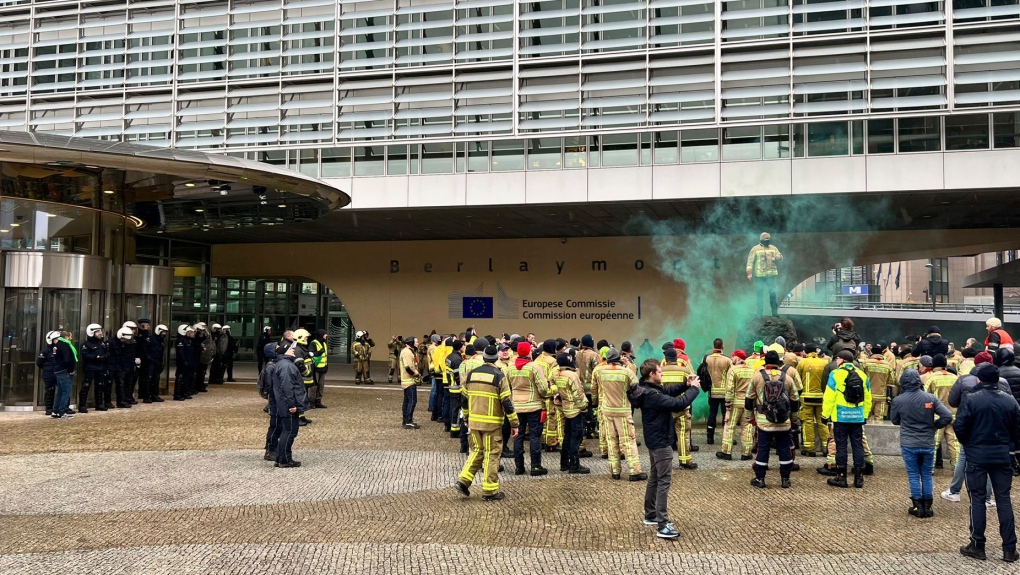 Police stand guard at the entrance of EU headquarters in Brussels during a demonstration of firefighters in Brussels, Tuesday, March 7, 2023. (AP Photo/Sylvain Plazy)
