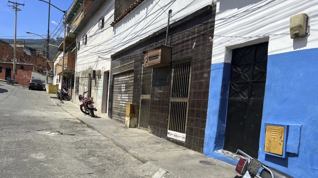 The second house from right to left, with a 'No Parking' sign in Spanish on the door of its garage is the listed address of one of the startups involved in a massive corruption scandal that bilked billions of dollars in Venezuelan oil, and whose owner has never heard of the firm, at a working-class district in Caracas, Venezuela, Tuesday, March 28, 2023. (AP Photo/Regina Garcia Cano)