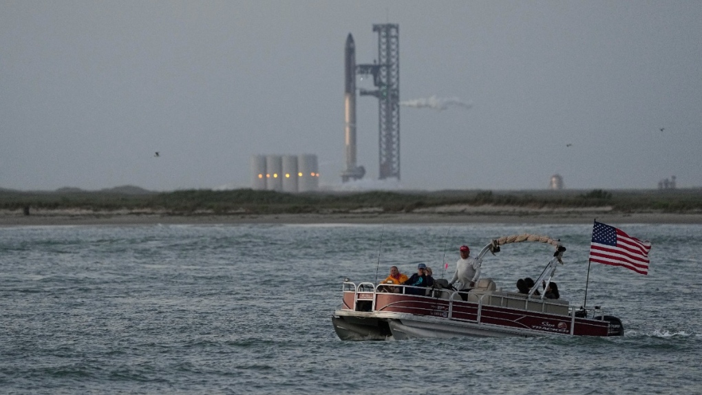 A boater passes SpaceX's Starship, the world's biggest and most powerful rocket, as it prepares to lift off from Starbase in Boca Chica, Texas, on April 17, 2023. (Eric Gay / AP) 