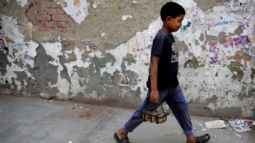 A child delivers tea to customers in Lucknow, India, Wednesday, June 1, 2016. A global slavery index puts India at the top of the list with the world's highest number of bonded and child labourers, far more than in second-place China. (AP Photo/Rajesh Kumar Singh)