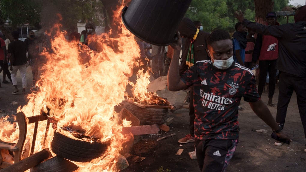 A demonstrator walks past a barricade set on fire during a protest in support of main opposition leader Ousmane Sonko in Dakar, Senegal, May 29, 2023. (AP Photo/Leo Correa)