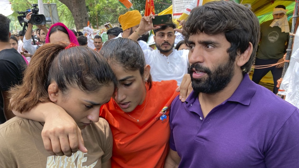 Indian wrestlers, from right, Bajrang Punia, Sangita Phogat and Vinesh Phogat talk to each other ahead of their protest march towards the newly inaugurated parliament, in New Delhi, India, Sunday, May, 28, 2023. India’s top wrestlers have been protesting for more than a month, demanding the resignation and arrest of the president of the wrestling federation for allegedly sexually harassing young athletes.(AP Photo/Shonal Ganguly)