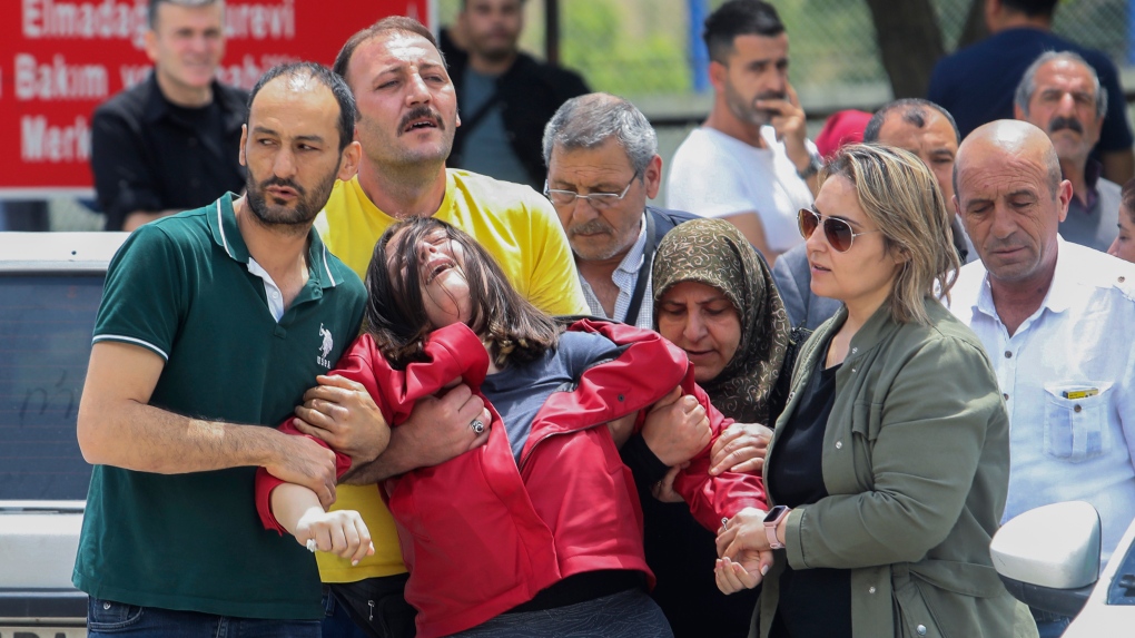 Relatives of workers gather outside a compound of the state-owned Mechanical and Chemical Industry Corporation on the outskirts of Ankara, Turkiye on June 10, 2023. An explosion at a rocket and explosives plant caused a building to collapse on Saturday, killing all five workers inside, an official said. (Yavuz Ozden/DIA Images via AP)