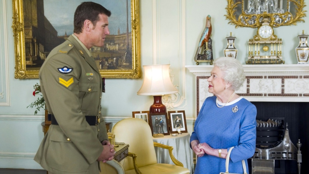 Queen Elizabeth II greets Corp. Ben Robert-Smith, from Australia, at Buckingham Palace in London, on Nov. 15, 2011. (Anthony Devlin / AP) 