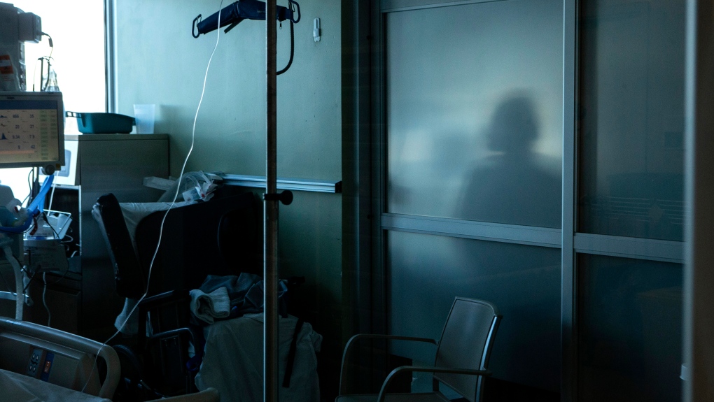 A nurse is silhouetted behind a glass panel as she tends to a patient at an Ontario hospital, on Tuesday, January 25, 2022. THE CANADIAN PRESS/Chris Young