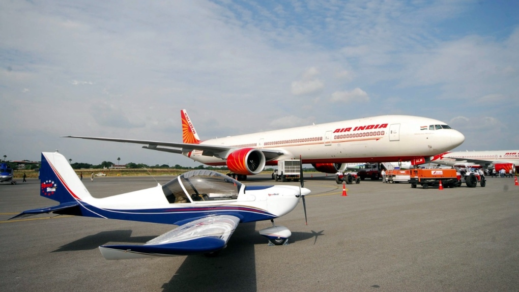 A two-seater Sport Star aircraft sits in front of the Air India Boeing 777 at the India Aviation 2008, a four-day air show in Hyderabad, India, Friday, Oct. 17, 2008. (AP Photo/Mahesh Kumar A.)